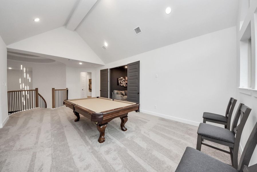 Expansive upstairs game room open to the living room below, offering plenty of space for entertainment and a theatre room just through the double doors.