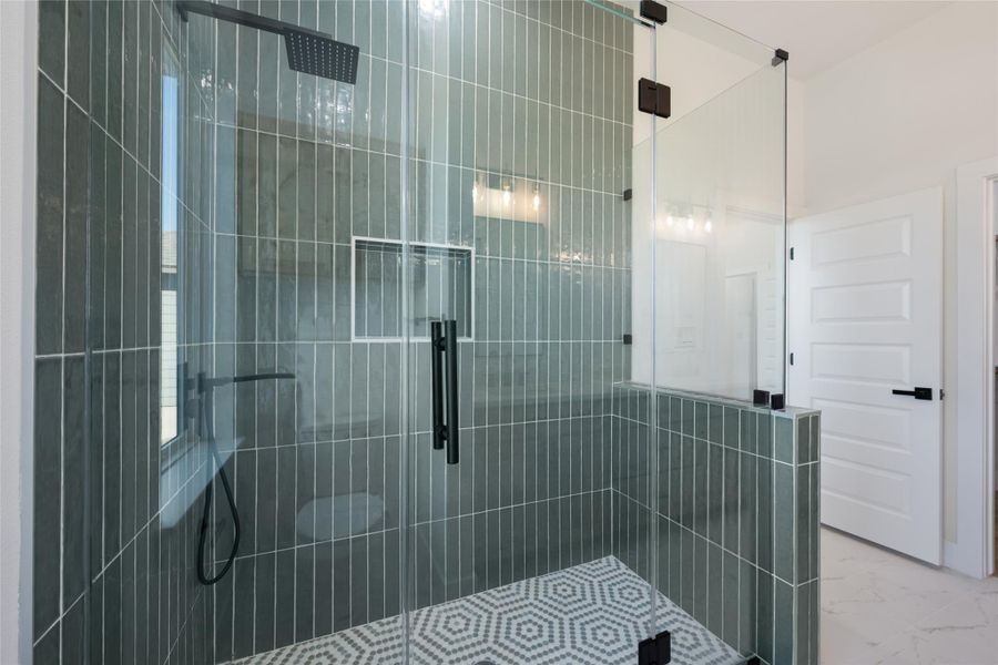 Bathroom with marble look tiles and a stall shower