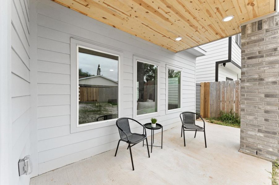 A charming covered patio in back is a perfect shady spot to relax outdoors.