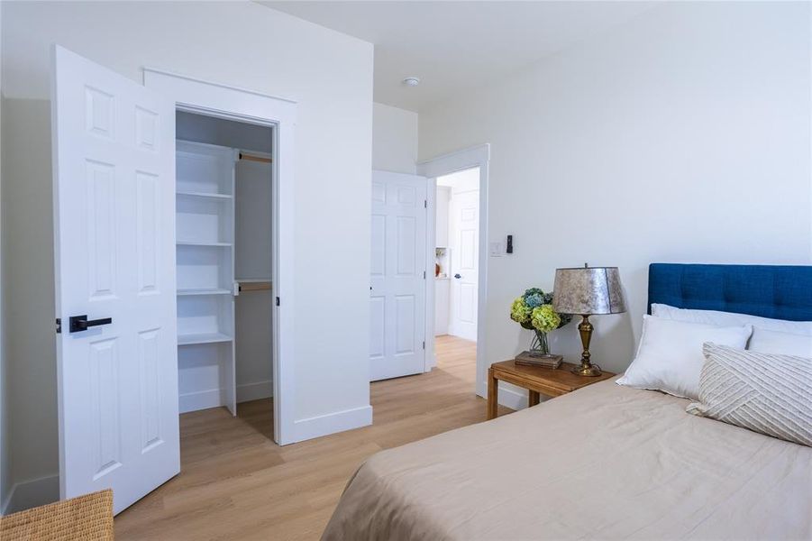 Bedroom with light wood-style floors and a spacious closet