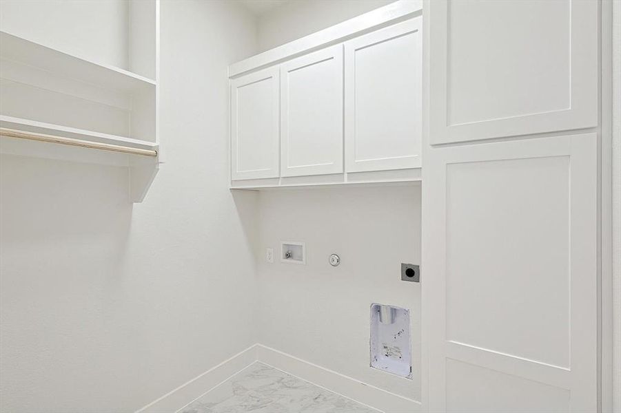 Clothes washing area featuring cabinets, hookup for an electric dryer, hookup for a gas dryer, and washer hookup