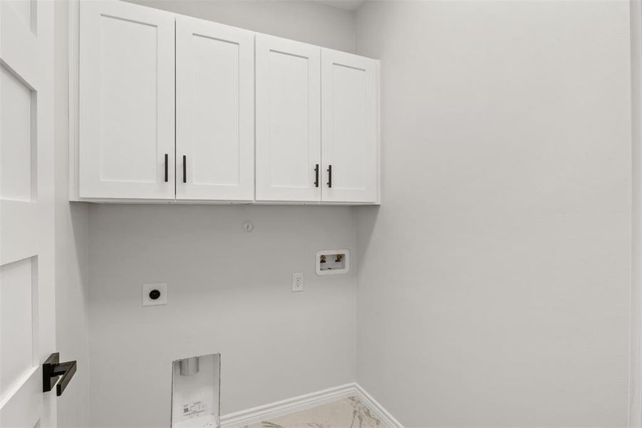Laundry area with cabinet space, hookup for a washing machine, electric dryer hookup, and light marble finish floors
