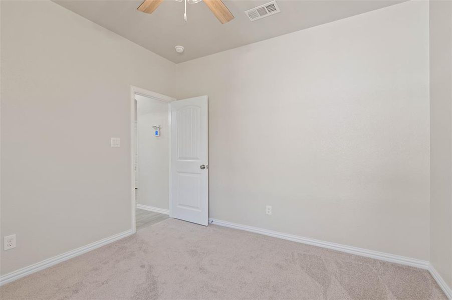 Carpeted spare room with ceiling fan