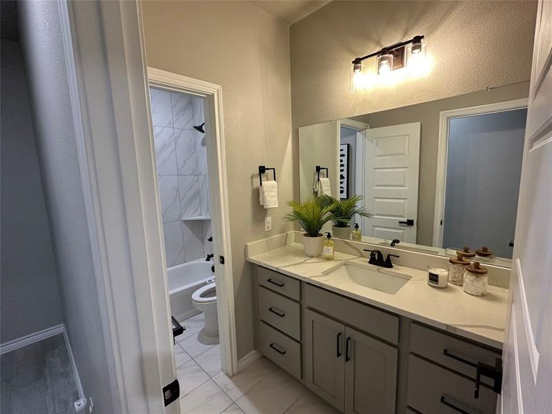 Full bath with vanity, baseboards, toilet, marble finish floor, and tub / shower combination Full bath with vanity, baseboards, toilet, marble finish floor, and tub / shower combination