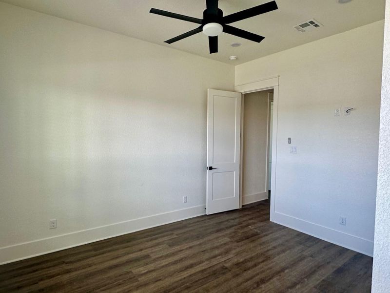 Spare room featuring dark wood-style flooring and ceiling fan