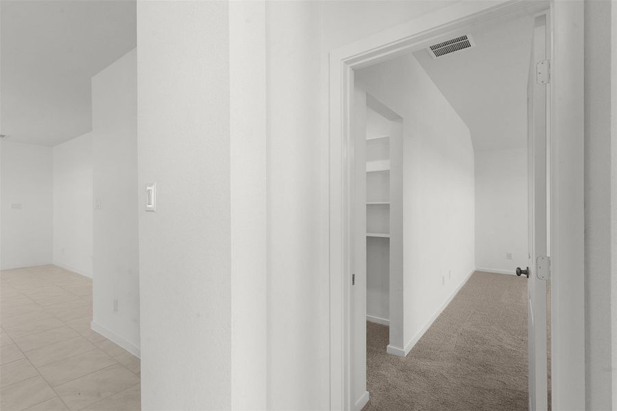 Hallway with baseboards and light colored carpet