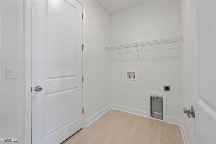 Laundry area with electric dryer hookup, washer hookup, and wood finish floors Laundry area with electric dryer hookup, washer hookup, and wood finish floors