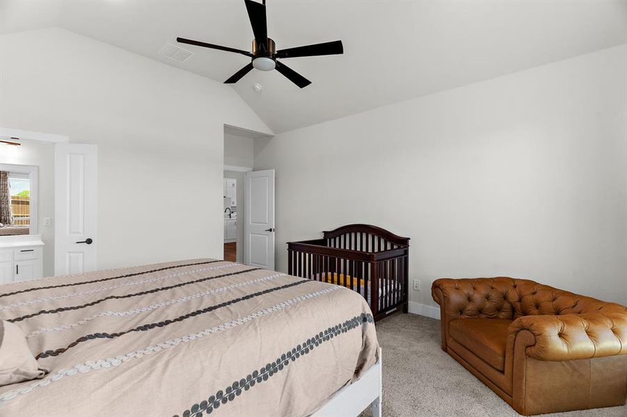 Bedroom featuring light colored carpet, a ceiling fan, baseboards, and high vaulted ceiling Bedroom featuring light colored carpet, a ceiling fan, baseboards, and high vaulted ceiling