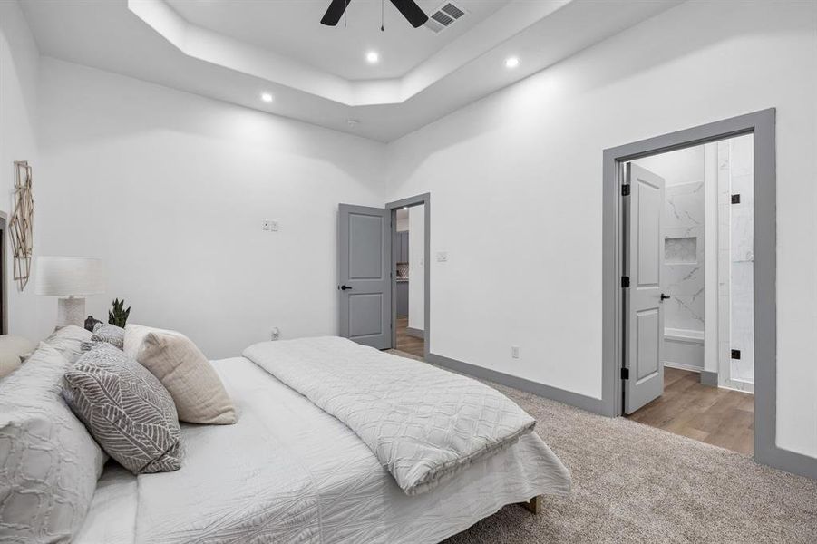 Here is a great view of the primary suite with the trayed ceiling and entrance to the main living area.