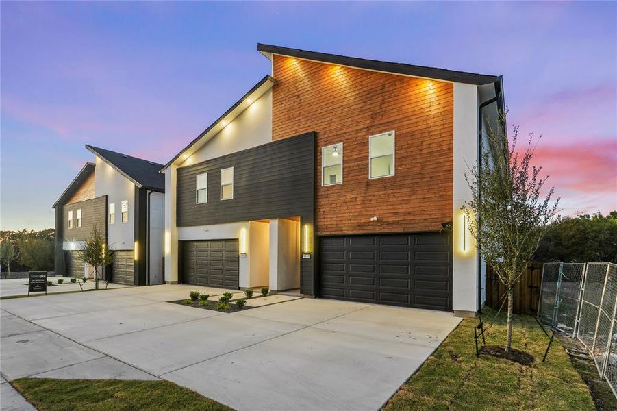 Contemporary home with an attached garage, driveway, and stucco siding