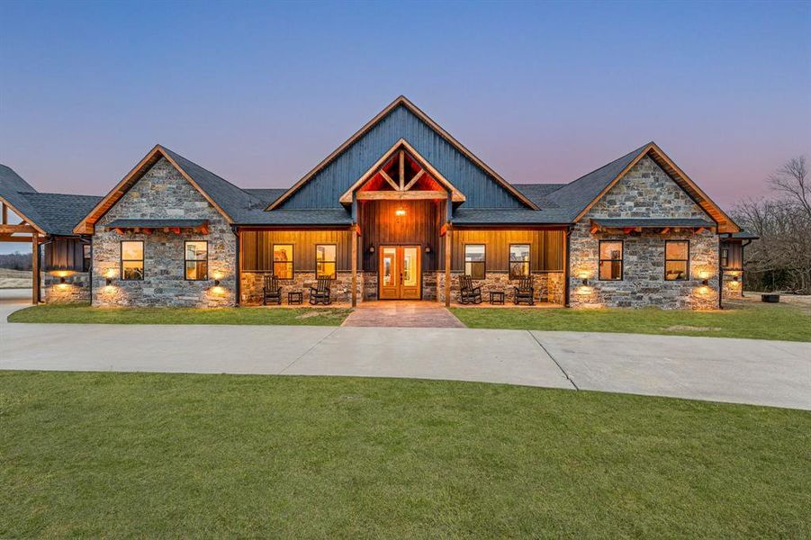 Craftsman-style home with a porch, stone siding, and a front lawn