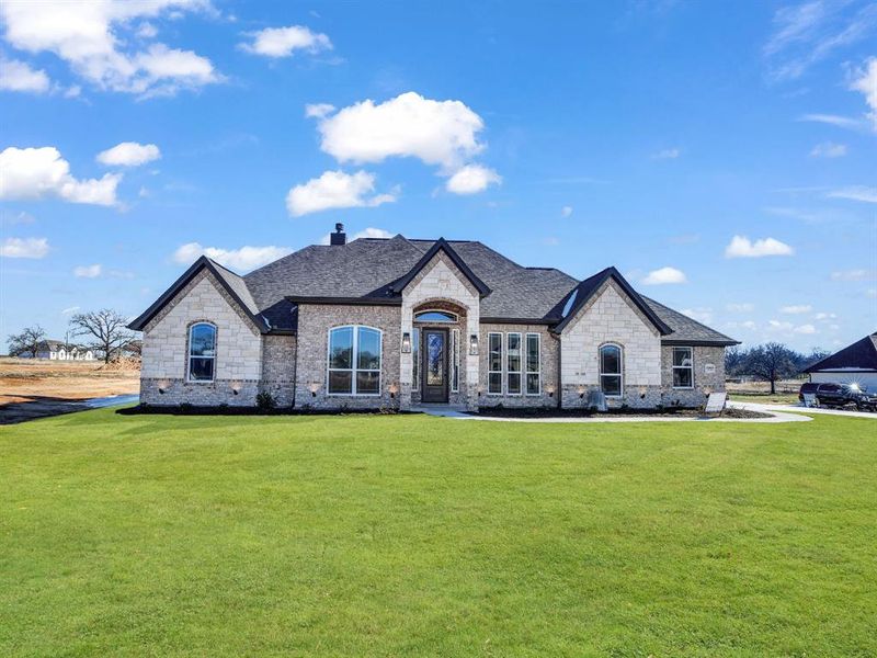 French provincial home featuring a front lawn