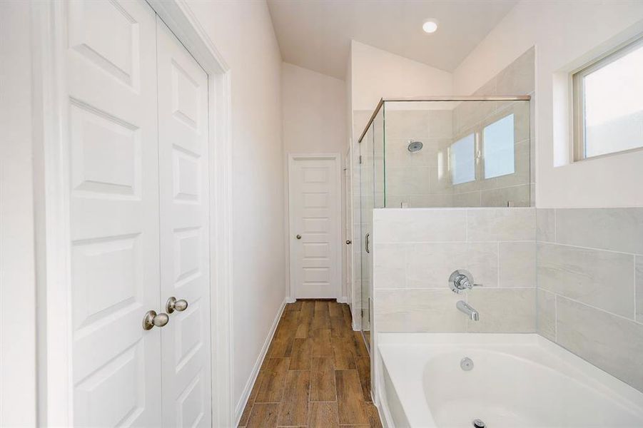 Luxurious primary bathroom featuring a sleek glass-enclosed shower, elegant tiling, and abundant natural light.