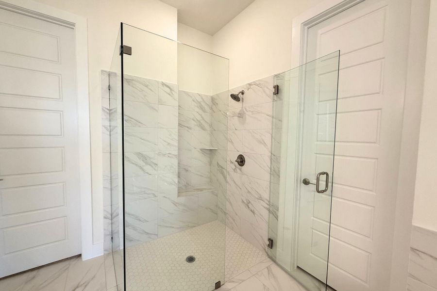 A spacious, modern walk-in shower features elegant tile and seamless glass enclosure, offering a serene bathing experience. A spacious, modern walk-in shower features elegant tile and seamless glass enclosure, offering a serene bathing experience.
