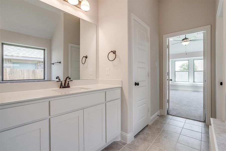 Bathroom featuring tile patterned flooring, vanity, and ceiling fan