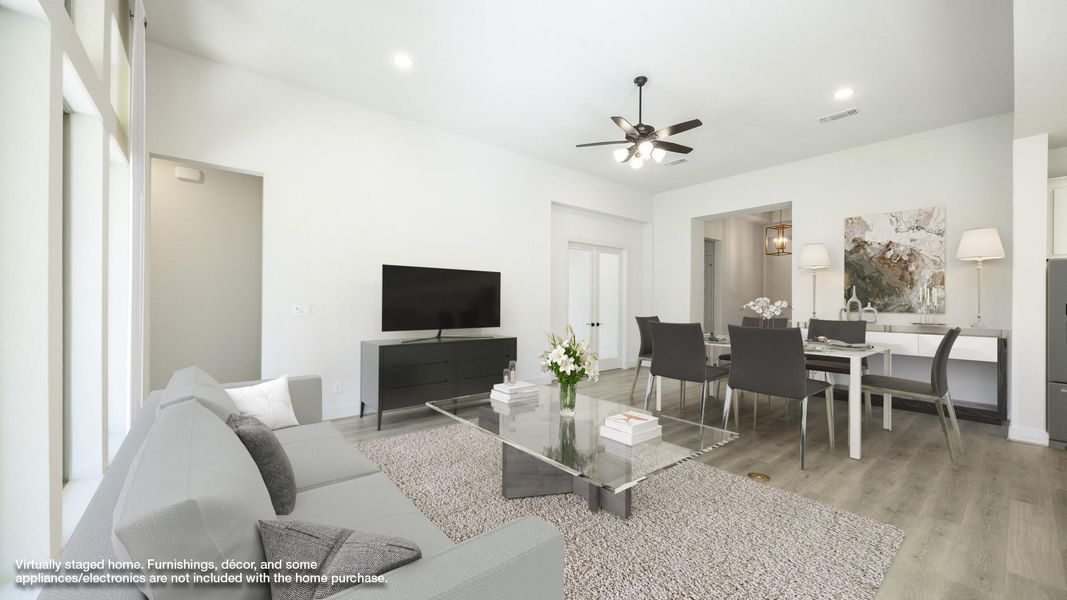 Living room with light wood finished floors, recessed lighting, and a ceiling fan