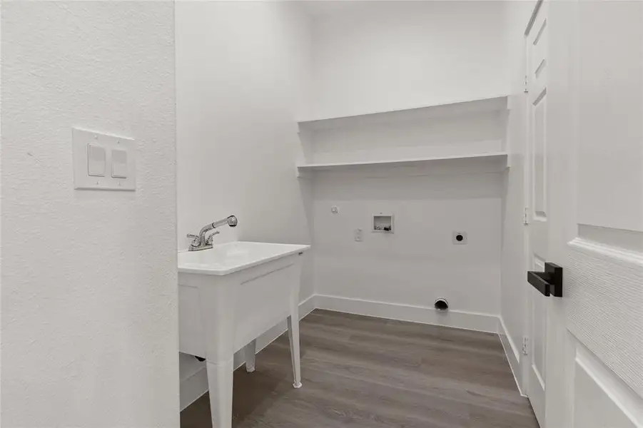 Laundry area with hookup for an electric dryer, dark wood-style floors, hookup for a washing machine, gas dryer hookup, and a textured wall
