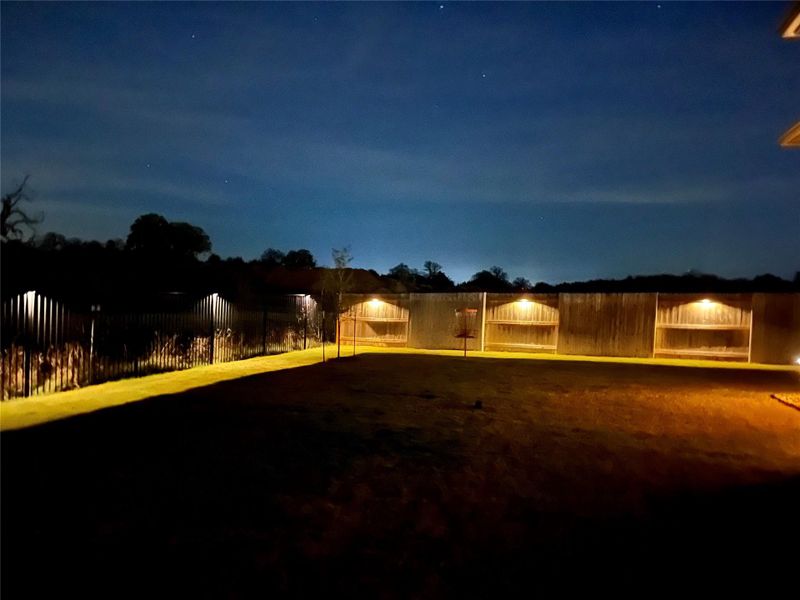 Secure yard featuring a well-maintained fence and ample outdoor lighting for evening enjoyment. Secure yard featuring a well-maintained fence and ample outdoor lighting for evening enjoyment.