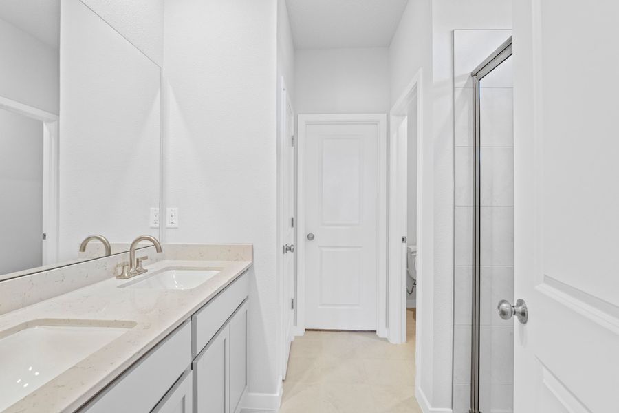 Lot 145 Primary Bath with Walk-In Shower and Dual Vanities at Camden Woods in Kingsland