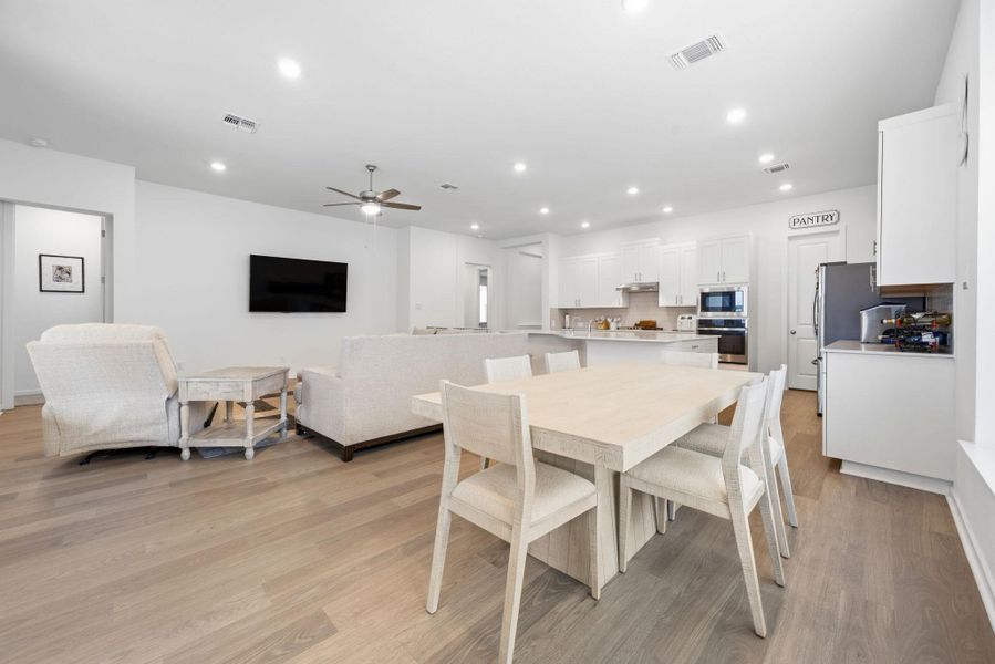 Dining space with light wood-style floors, recessed lighting, and ceiling fan