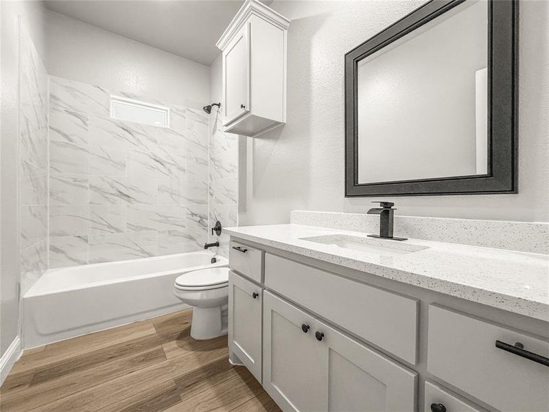 Bathroom featuring a white vanity with a quartz countertop, an undermount sink, and a matte black faucet Bathroom featuring a white vanity with a quartz countertop, an undermount sink, and a matte black faucet