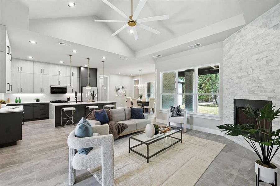 Living room with high vaulted ceiling, a ceiling fan, a fireplace, and recessed lighting