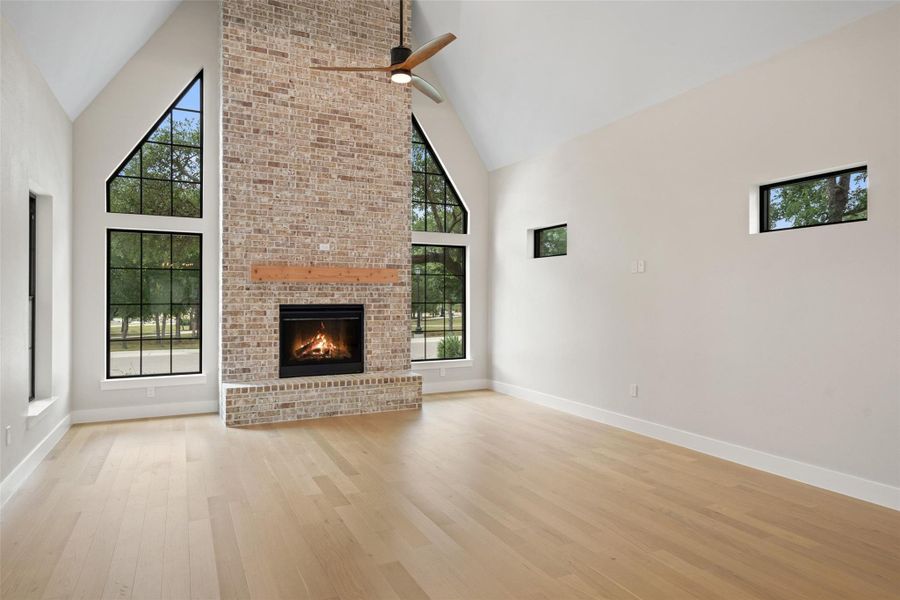 Vast vaulted ceilings and a floor-to-ceiling brick fireplace anchor this airy, naturally illuminated great room. Vast vaulted ceilings and a floor-to-ceiling brick fireplace anchor this airy, naturally illuminated great room.