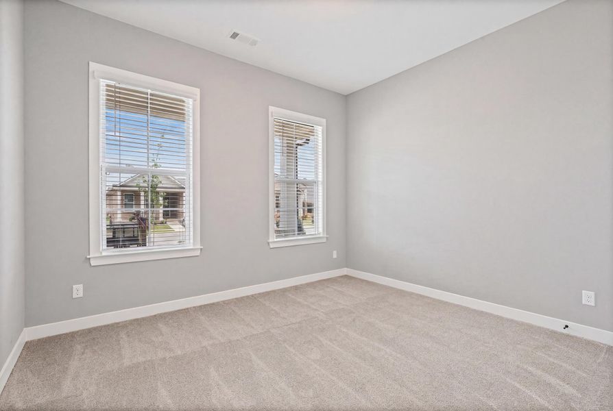 Neutral-toned room featuring a light gray wall color and plush carpeting Neutral-toned room featuring a light gray wall color and plush carpeting