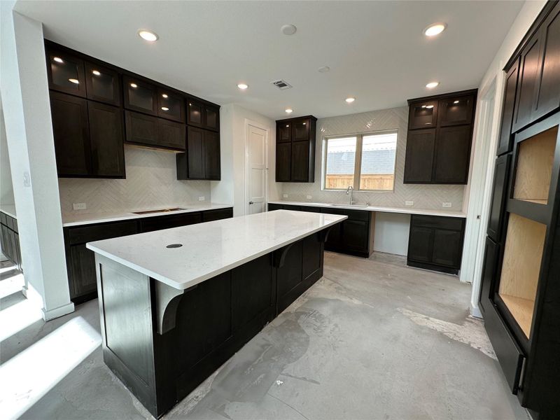 Discover the heart of the home with rich, dark brown cabinets, softly lit glass doors, and sleek stainless steel appliances (to be installed) that will complete this stunning, welcoming kitchen. Discover the heart of the home with rich, dark brown cabinets, softly lit glass doors, and sleek stainless steel appliances (to be installed) that will complete this stunning, welcoming kitchen.