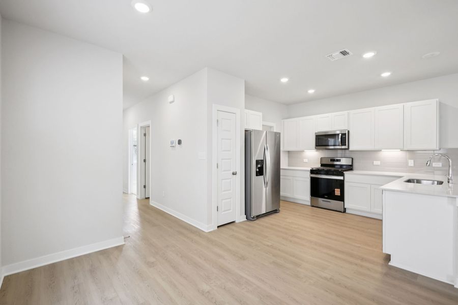 A kitchen with white cabinets.