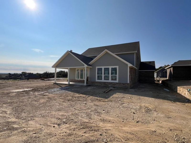 View of front facade featuring a patio and stone siding