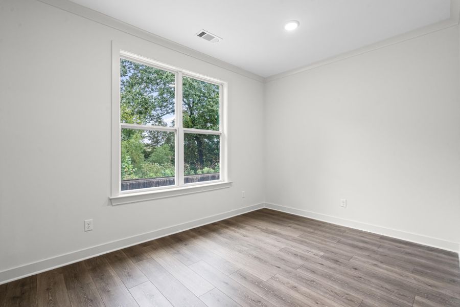 Unfurnished room with wood finished floors and ornamental molding