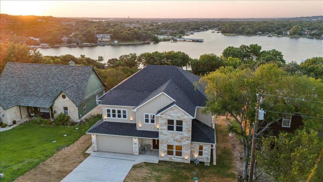 Aerial view at dusk featuring a water view