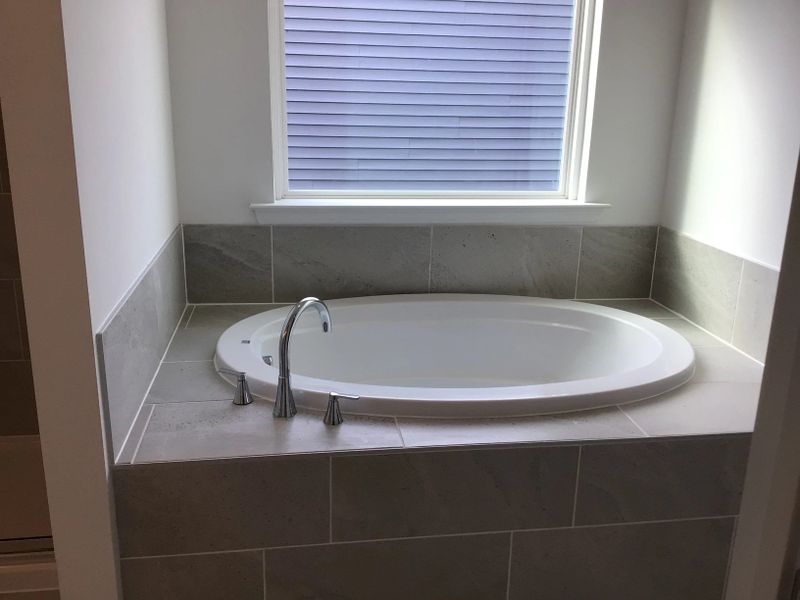 Primary Bath featuring the AW Collection® Coastal - Spa-like with white cabinets and light tile.