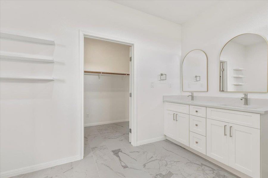 Dual vanity with sleek mirrors and spacious cabinetry define this well-appointed bathroom. Dual vanity with sleek mirrors and spacious cabinetry define this well-appointed bathroom.
