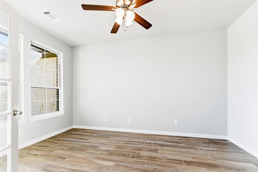 Unfurnished room featuring light wood-type flooring and a ceiling fan