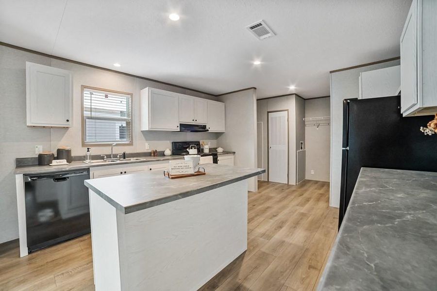 Kitchen featuring white cabinets, black appliances, recessed lighting, and a center island Kitchen featuring white cabinets, black appliances, recessed lighting, and a center island