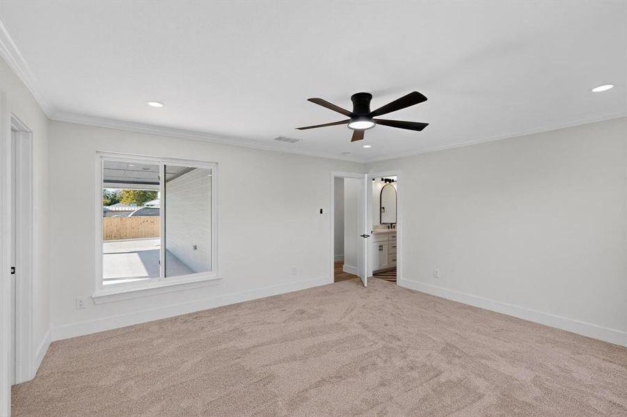 Unfurnished bedroom with crown molding, recessed lighting, light colored carpet, ceiling fan, and ensuite bathroom