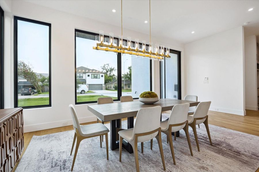 Dining area with modern chandelier, floor-to-ceiling windows, and natural light. Dining area with modern chandelier, floor-to-ceiling windows, and natural light.