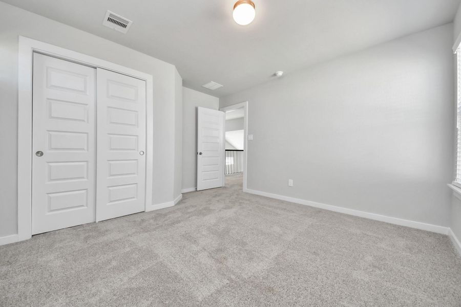 Generously sized secondary bedrooms featuring spacious closets, soft and inviting carpeting underfoot, large windows allowing plenty of natural light, and the added touch of privacy blinds for your personal retreat. Sample photo of completed home with similar floor plan. Actual colors and selections may vary.