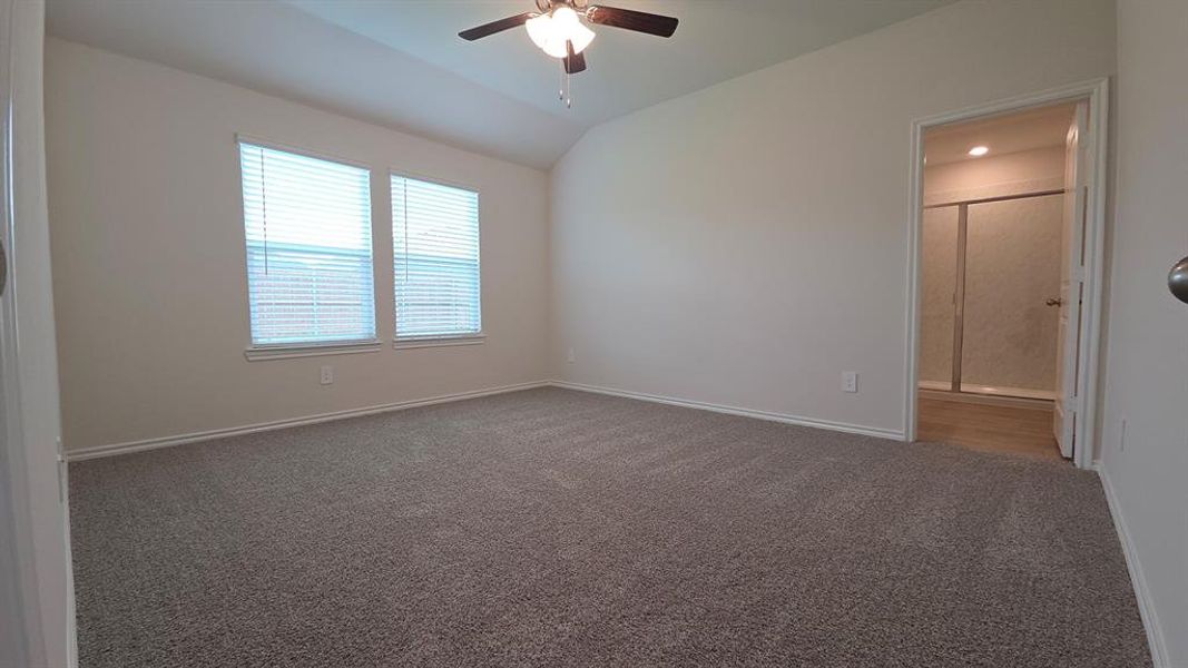 Spacious room with vaulted ceiling and neutral carpeting