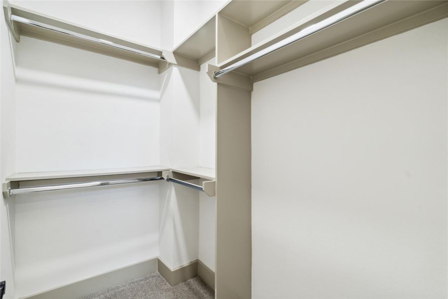 A meticulously designed walk-in closet offering ample storage and display options for wardrobe essentials.