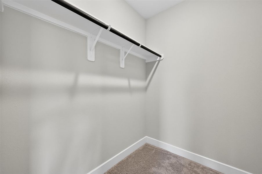 Spacious closet with built-in shelving and hanging storage, ideal for organizing wardrobe essentials.
