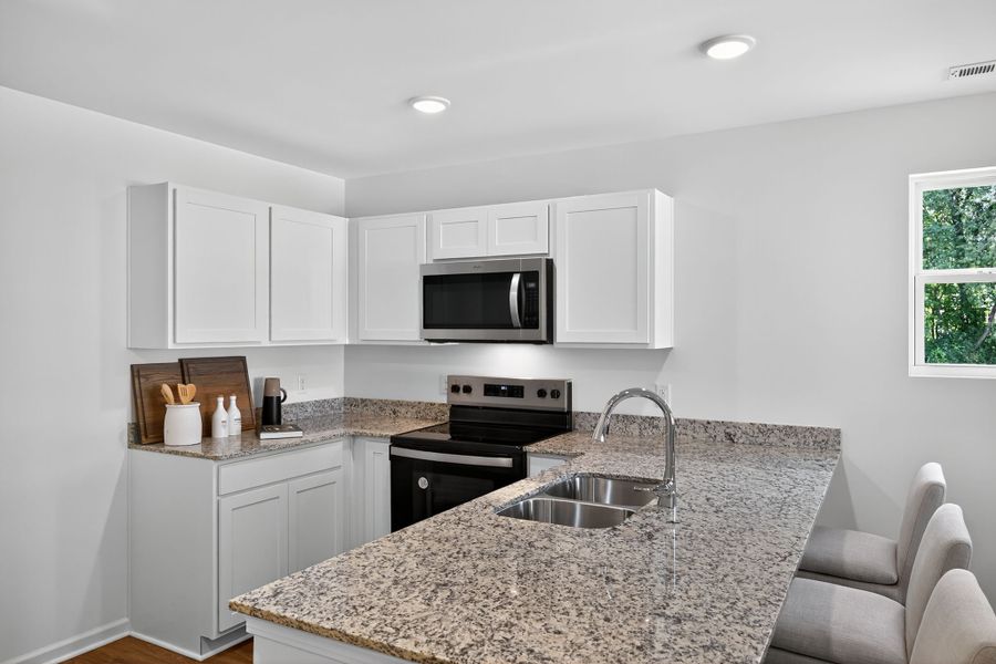 A kitchen with white cabinets.