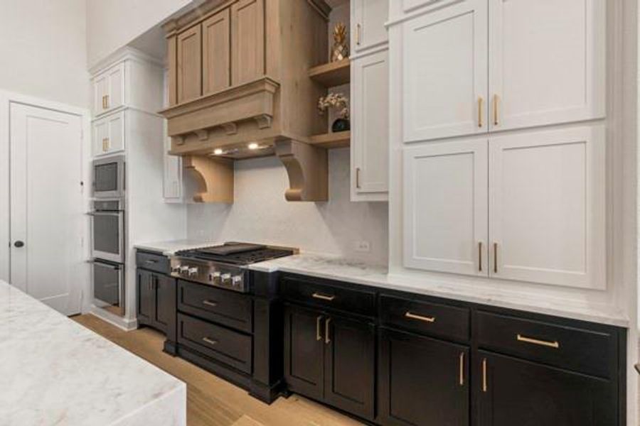 Kitchen featuring dark cabinets, white cabinets, open shelves, and light stone countertops
