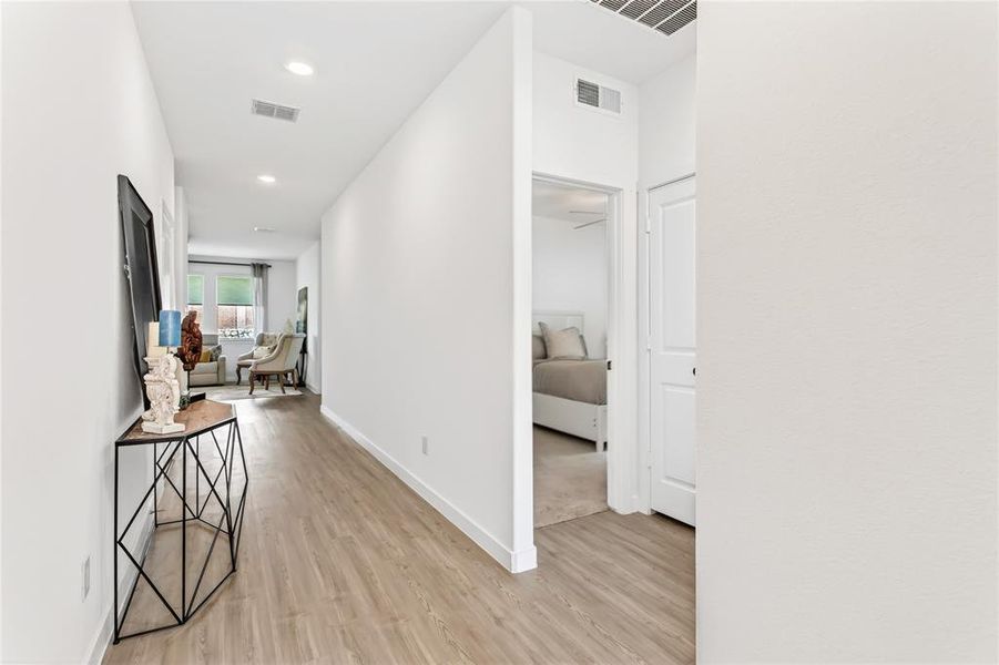 Hallway with light wood-style flooring and recessed lighting