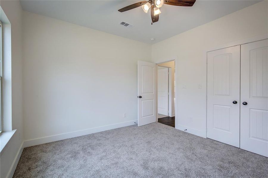Unfurnished bedroom with carpet flooring, a ceiling fan, and a closet Unfurnished bedroom with carpet flooring, a ceiling fan, and a closet