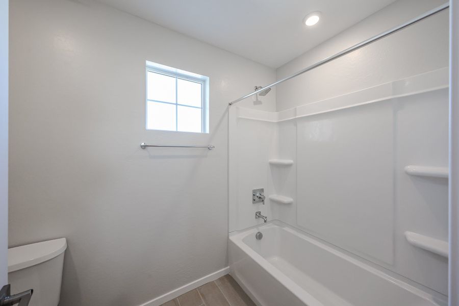 A bathroom with a tub and toilet. A bathroom with a tub and toilet.