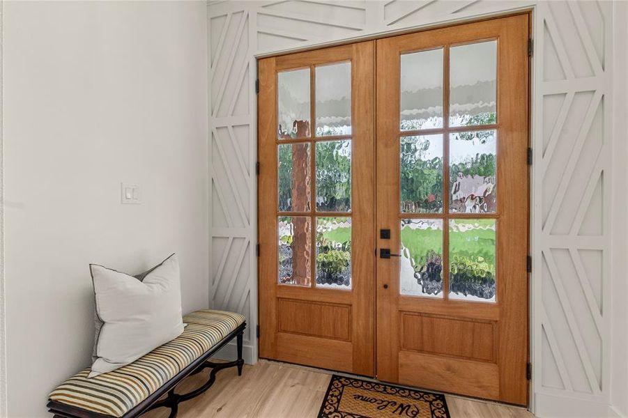 Doorway with light wood-type flooring, french doors, and a water view Doorway with light wood-type flooring, french doors, and a water view
