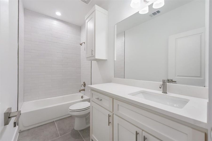 Full bath featuring washtub / shower combination, vanity, light tile patterned flooring, and recessed lighting
